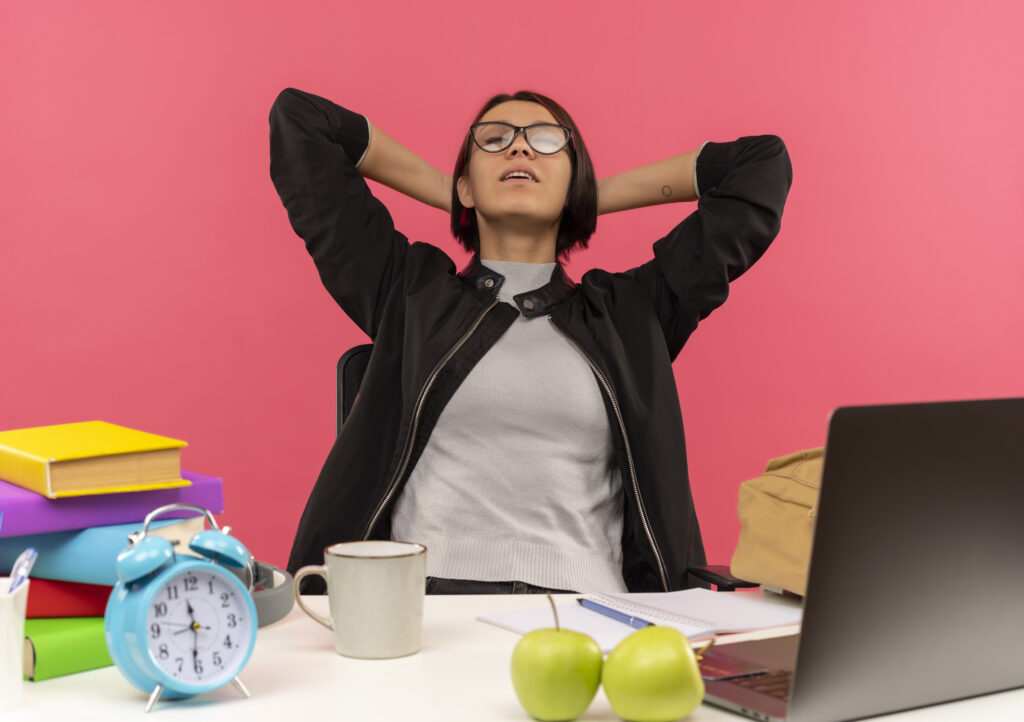 peaceful-young-student-girl-wearing-glasses-sitting-desk-putting-hands-neck-with-closed-eyes-isolated-pink-background-1024x722 Overcoming Stress in Today's Youth